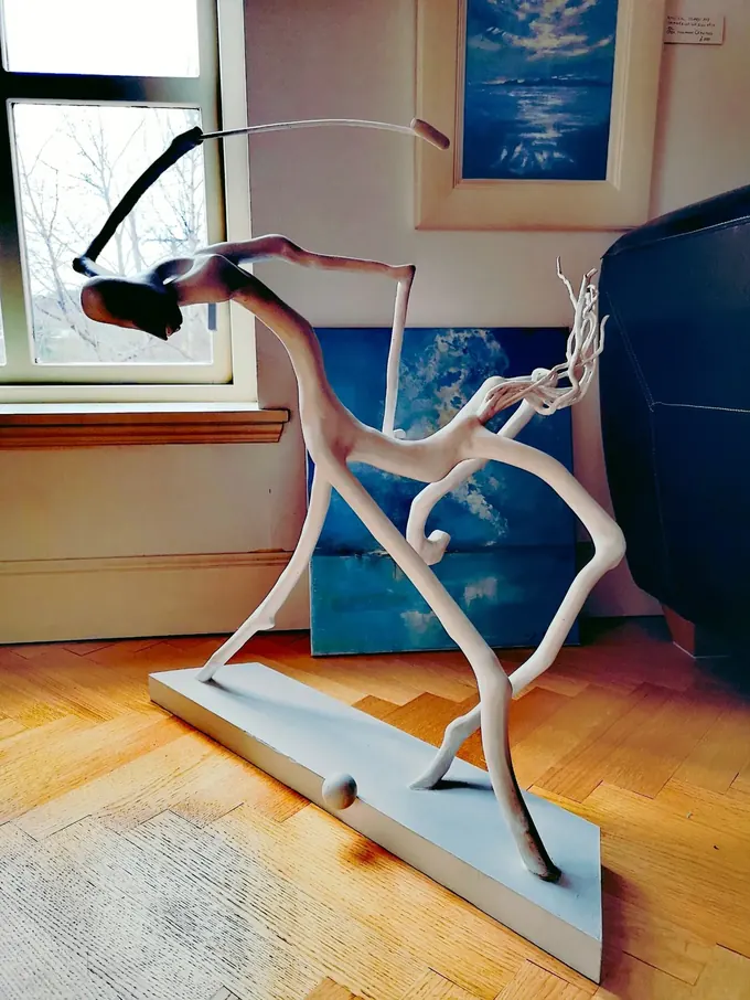 Centaur Playing Polo, a carved wood sculpture by Bruce Thomson of a centaur stretched forward at the gallop with a mallet swung back