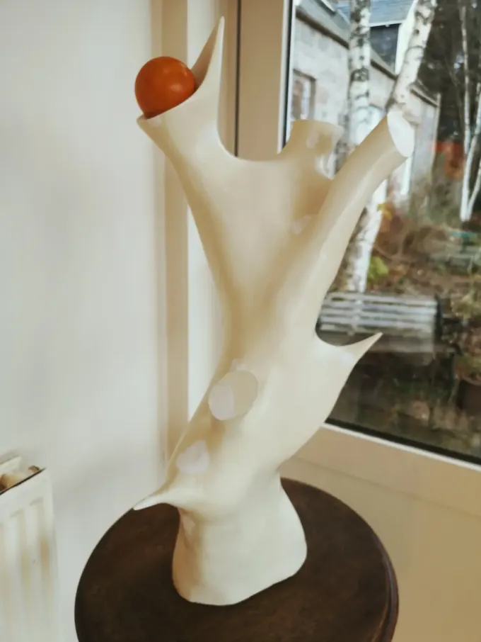 Natural Form, a carved wood sculpture by Bruce Thomson, a pale branching form with an orange sphere resting in the fork
