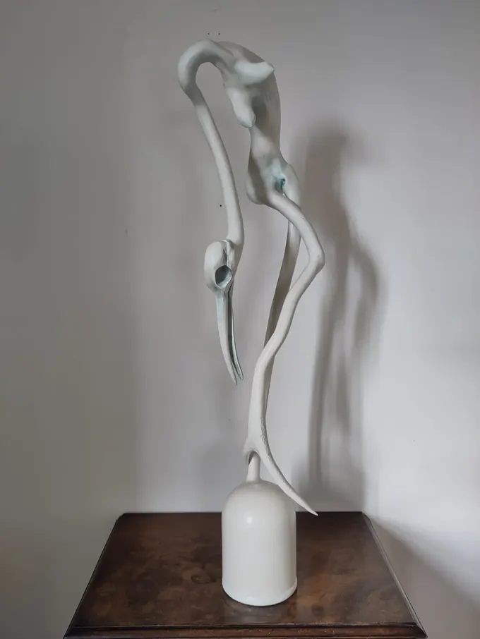 Antler Bird Woman, a carved wood sculpture by Bruce Thomson, a long neck bending to a beaked head with a torso rising behind